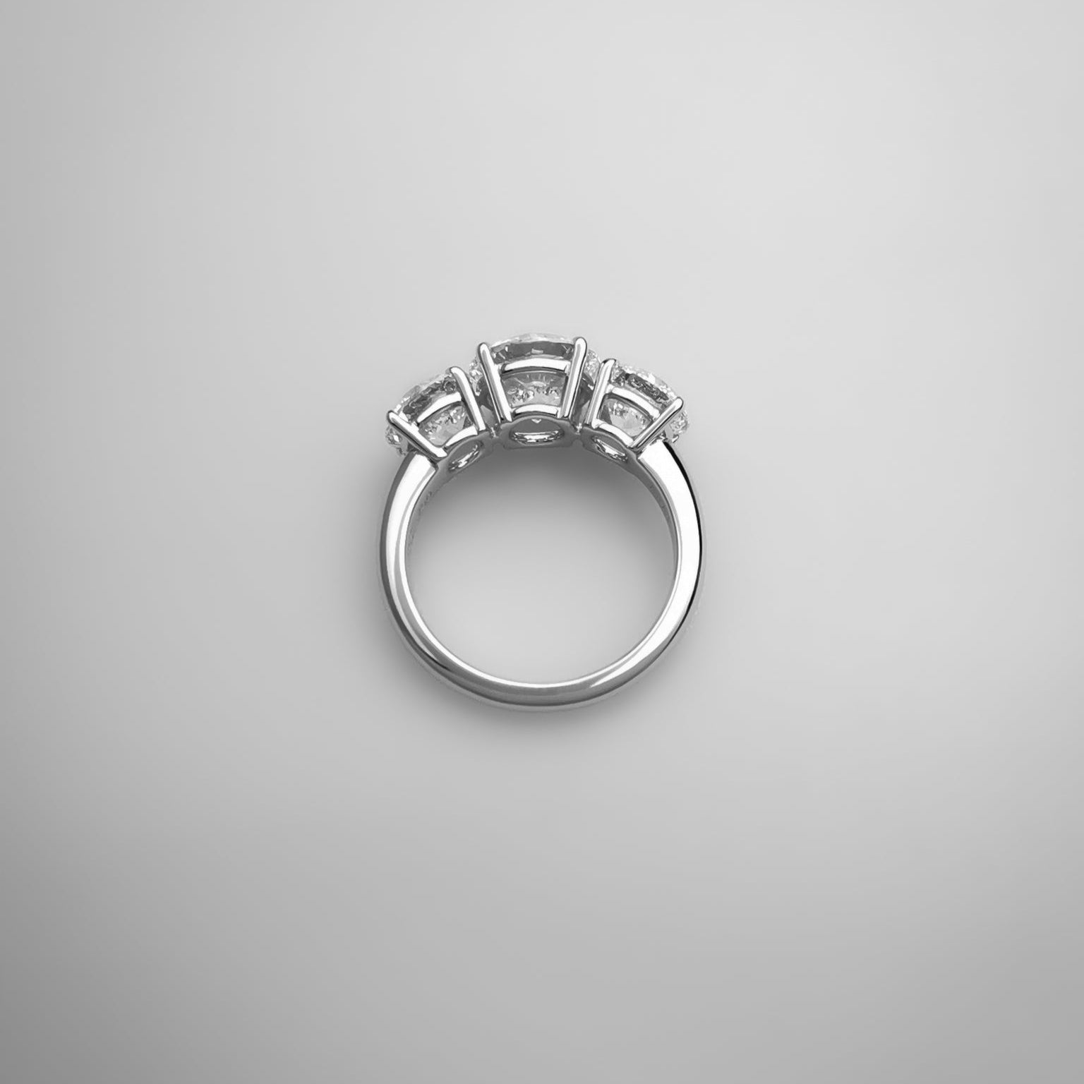 Silver ring with three diamonds on a gray background