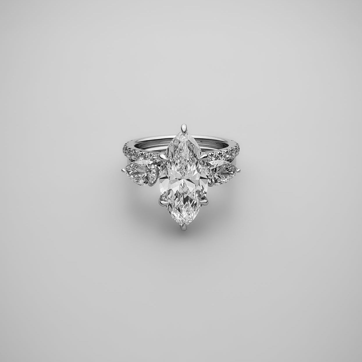 Marquise diamond ring with pear side stones stacked with eternity band