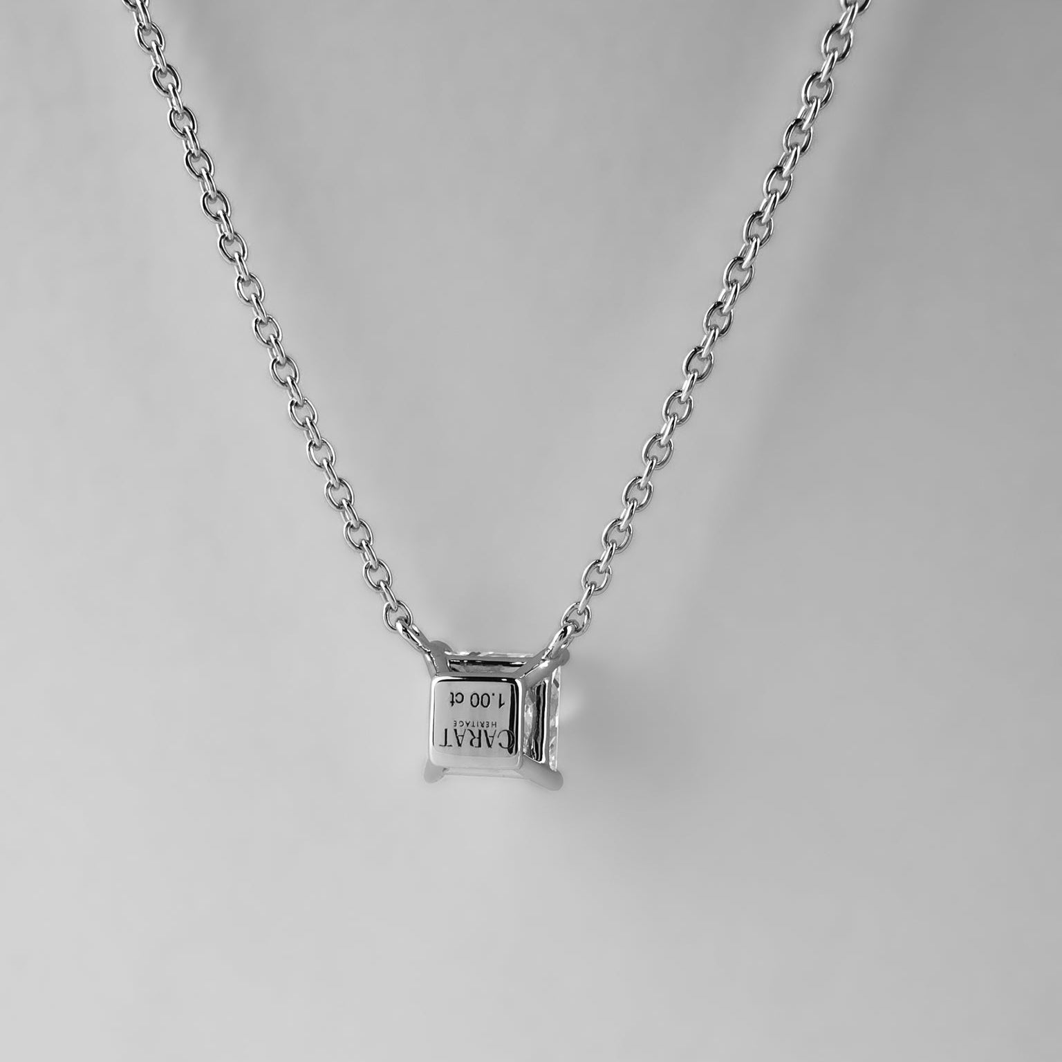 Silver necklace with a small pendant on a light gray background