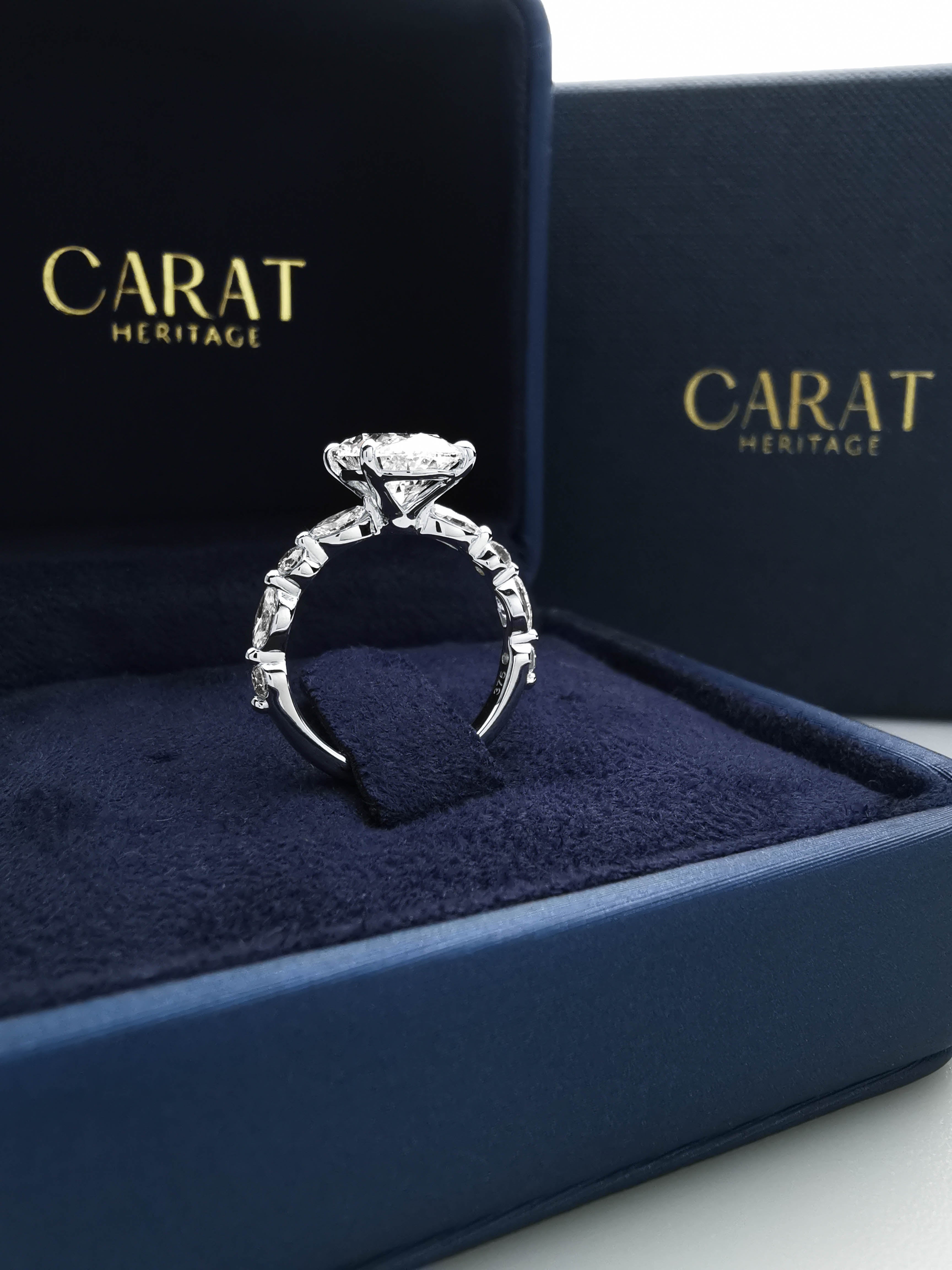 3ct Oval diamond ring with alternating Marquise and Round side diamonds in ring box