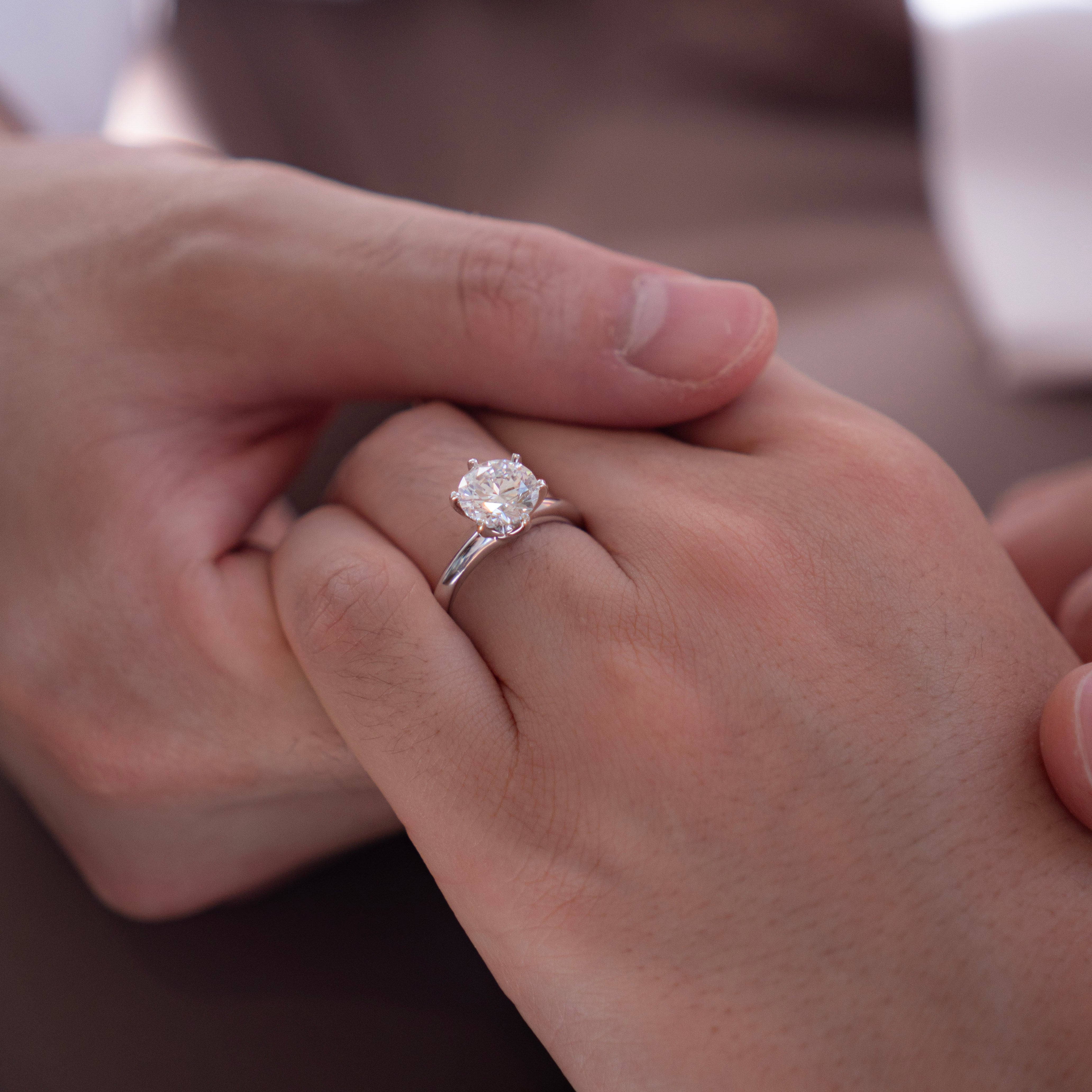 2 carat round 6 prong setting ring close up on hand