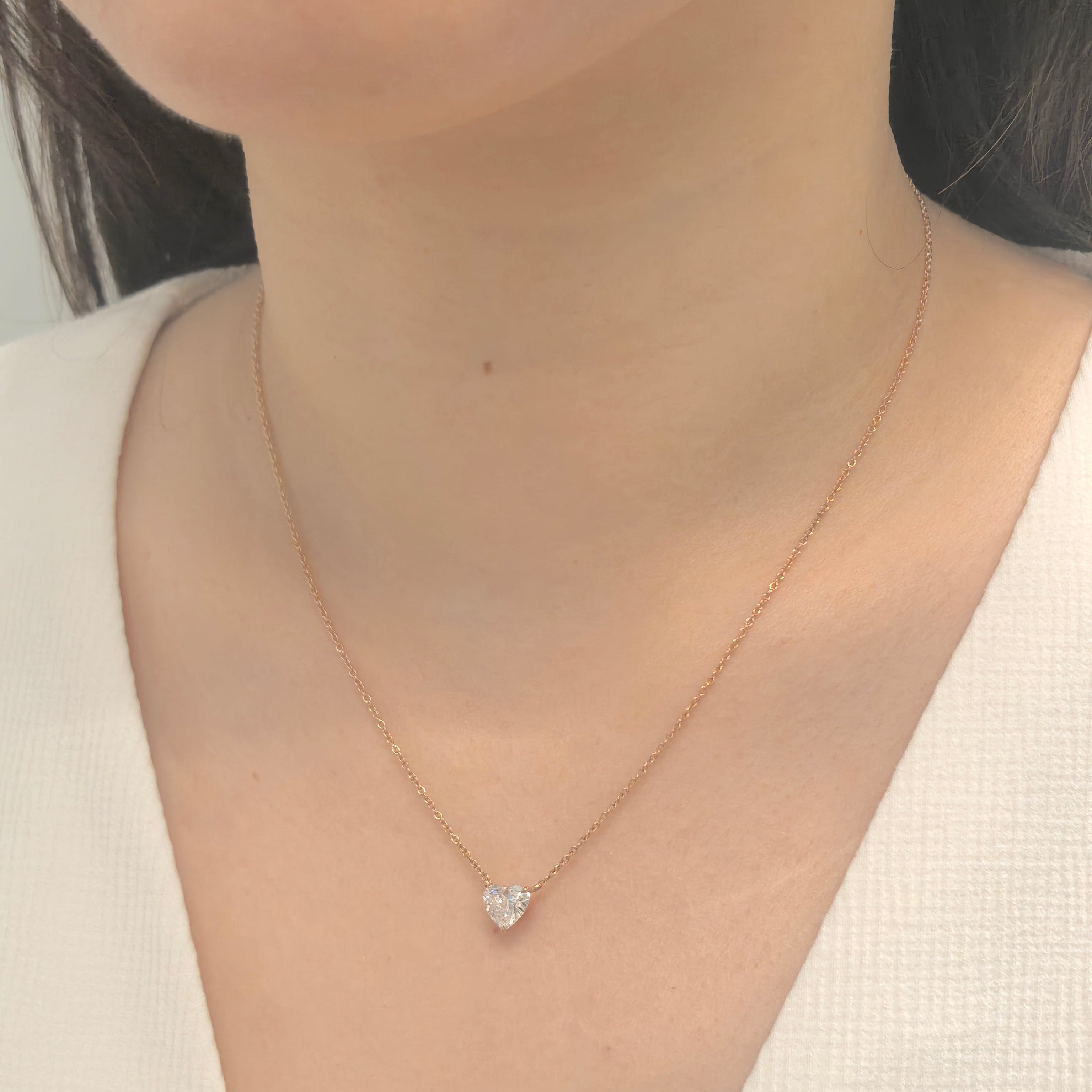 Necklace with a heart-shaped pendant worn by a person