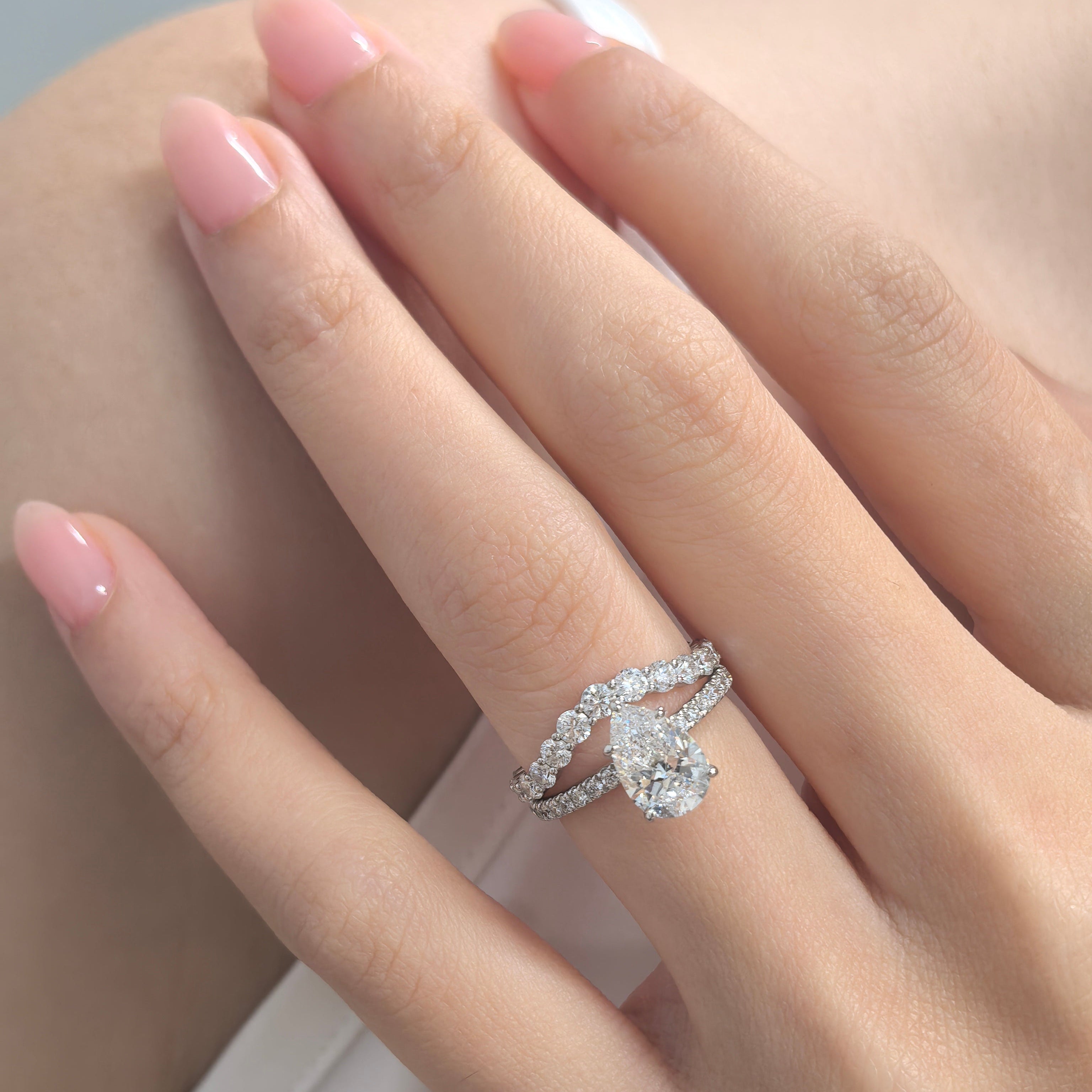 Pear on Melee ring stacked with curved eternity band